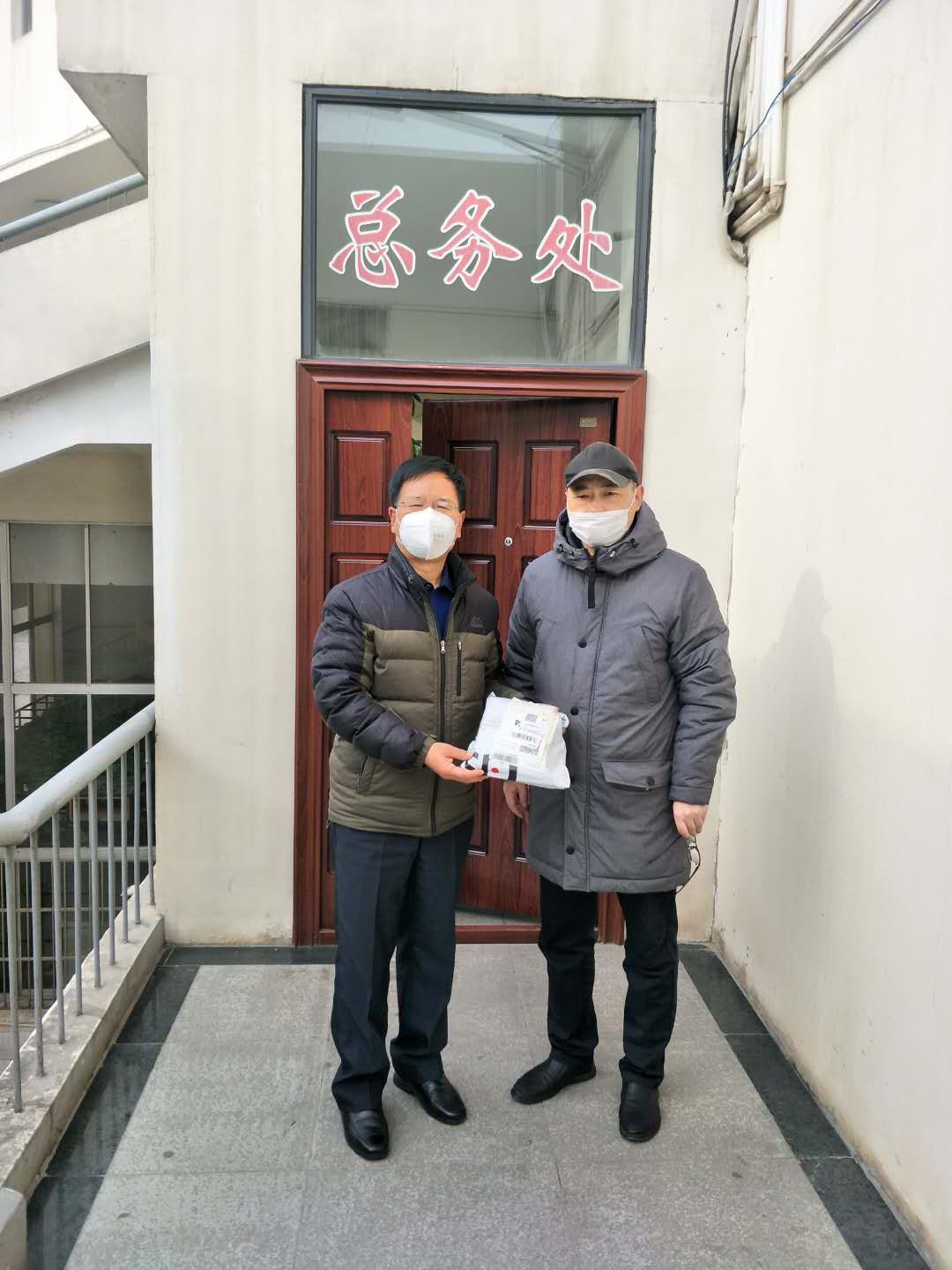 杨华将韩国大邱大邱大学捐赠的口罩转交给学院总务处