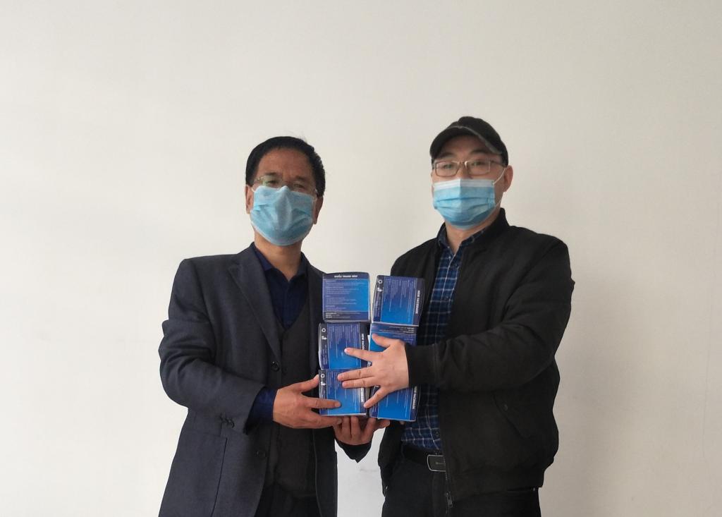 国际合作交流中心负责人杨华代表外教Lila向学院转交口罩,总务处处长郭宝东代表学院接收捐赠